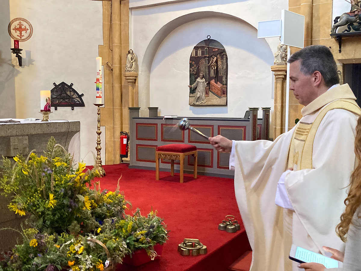 Pfarrer Martin Laskewicz segnet die Kräuterbüschel beim Gottesdienst in der St. Georgskirche, Niederwerth (Foto: Brehm)